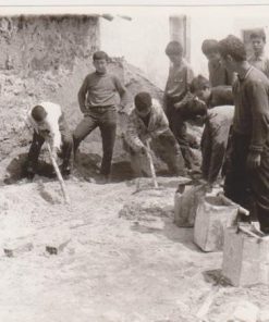 [Γεωργικά, Αρέθουσα Θεσσαλονίκης]:  Φωτογραφία ασπρόμαυρη - στο πίσω μέρος της σημειώνεται: "Αγροτόπαιδες Σχολείου Γεωργ. Τεχνικής Αρεθούσης εκπαιδευόμενοι εις την τέχνην του οικοδόμου υπό ειδικού τεχνίτου", διαστάσεις 18Χ12